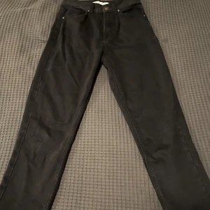 Svarta byxor från Bershka - Säljer ett par svarta byxor från Bershka i storlek EUR 34. Byxorna har en klassisk design med fem fickor och knappstängning. Perfekta för både vardag och fest. De är i mycket bra skick och redo för en ny ägare!