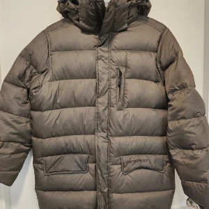 Khakigrön dunjacka från Everest - Säljer en varm och skön khakigrön dunjacka från Everest i storlek XS. Jackan har en praktisk huva och dragkedja framtill. Perfekt för kalla vinterdagar med sitt 70% dunfoder. Den är i mycket bra skick och redo för nya äventyr! 🧥❄️