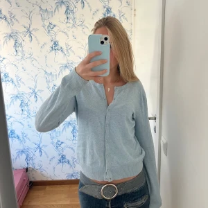 Ljusblå kofta - Säljer en superfin ljusblå kofta i mycket bra skick. Den har långa ärmar och knappar framtill. Fint skick!