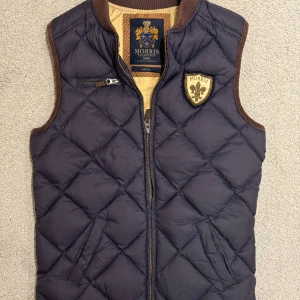 Marinblå Väst från Morris - Storlek: S Färg: Mörkblå Skick: Mycket bra skick Small-taggen är halvt lös men det är en enkel fix som tar någon minut med någon som kan sy. Men annars inga synliga defekter och i perfekt skick. Se sista bild. 