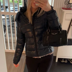 Svart pufferjacka - Säljer en snygg marinblå pufferjacka i mycket bra skick. Den är perfekt för höst och vinter med sin varma och vadderade design. Jackan har en dragkedja framtill och långa ärmar. Den är i storlek XS/S och passar perfekt för kyliga dagar.