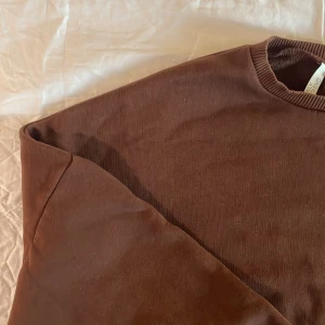 Brun tröja från Nelly.com - Mysig brun tröja från Nelly.com i storlek S. Perfekt för höst och vinter med sin varma och bekväma design. Tröjan har långa ärmar och ribbade muddar vid ärmslut och nederkant. Ett måste för garderoben!