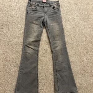 Grå lågmidjade bootcut jeans från Kidsbrandstore  - Snygga grå bootcut jeans från D-XEL i storlek 176. Skulle säga att de passar för någon som är ungefär 168-170 cm lång. Bra skick! Kontakta för fler bilder!
