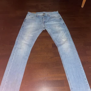 Dondup george W33 - Säljer ett par ljusblå dondup jeans då de aldrig kom i användning. Väldigt bra skick med snygga slitningar. Storleken är w33 