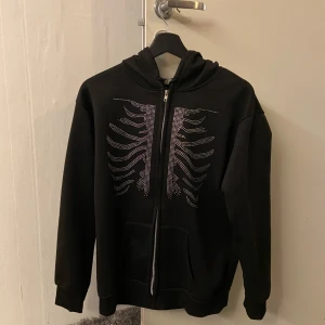 Rhinestone zip hoodie - Hej, jag säljer en svart Rhinestone zip hoodie. Hoodien är i toppskick och har alla paljetter kvar. En väldigt bekväm zip hoodie med en snygg design på framsidan. Den perfekta julklappen att ge någon! 🎁☃️❄️