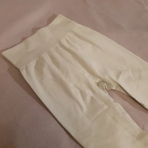 Ljusgula ribbade leggings från H&M Sport - Säljer ett par superbekväma ljusgula ribbade tights från H&M Sport i storlek XS (stretchiga så passar XS och S). Perfekta för träning eller mysiga hemmadagar. De är stretchiga och har en hög midja som ger en skön passform. Lapp bortklippt men sparsamt använda så i bra skick! 