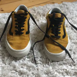 Säljer ett par coola gula Vans sneakers i storlek 36. De har en snygg svart detalj på sidan och är i bra skick. Perfekta för vår och sommar! 🖤💛