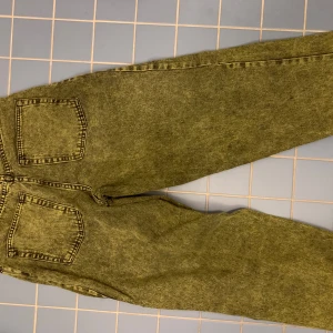 Gröna jeans från Big Boy - Säljer ett par coola gröna jeans från Big Boy i storlek XS. De har en loose fit och är perfekta för en avslappnad stil. Jeansen har klassiska fem fickor och en knappgylf. Perfekta för höst och vår!