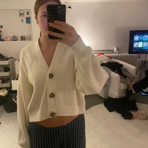 Vit stickad kofta från H&M - Säljer en superfin vit stickad kofta från H&M i storlek M. Den har stora knappar framtill och är perfekt för både höst och vår. Koftan är i använt skick och passar perfekt till både jeans och kjol. Perfekt för en mysig dag hemma eller en fika på stan! 🤍