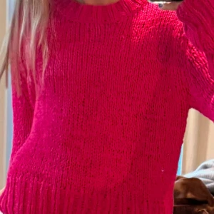 Rosa stickad tröja - Säljer en härlig rosa stickad tröja med rund hals och långa ärmar. Perfekt för kyligare dagar och ger en färgklick till din garderob. Passar bra till jeans eller kjol för en avslappnad look.