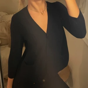 Trekvartsärmad kofta från COS - Snygg svart/mörkblå kofta från COS med knappar framtill. Den har trekvartsärmar och är skön i materialet.💕