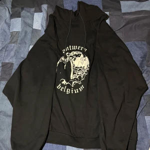Svart hoodie från Raf Simons Archive Redux - Cool svart hoodie med tryck av 'Antwerp Belgium' och en unik design på framsidan. Perfekt för en avslappnad stil med en touch av mode. Huvan har dragsko för justerbar passform. Dm vid frågor 