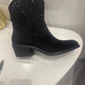 Svarta boots från Boshimao 41 - Snygga svarta boots i mocka med utskurna detaljer och en bekväm klack. Perfekta för en stilren look.