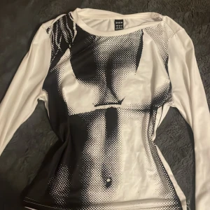 Snygg Vit långärmad topp från Shein - Säljer en vit långärmad topp från Shein med ett unikt svartvitt tryck på framsidan. Perfekt för att ge din outfit en edgy touch. Toppen är i bra skick och passar perfekt till både vardag och fest. Skicka ett meddelande vid intresse!   (Original pris 70-90kr)