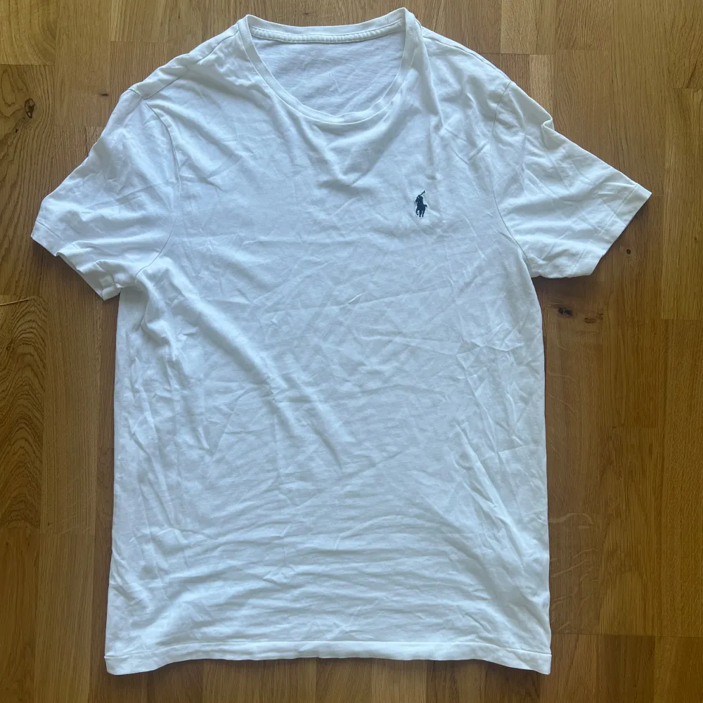 Säljer en vit t-shirt från Polo Ralph Lauren! Skick 9/10 Nypris 1100kr. Storlek M men passar även S. Perfekt för en avslappnad och stilren look. Autentikerad med qr-kod (se bild). Priset är ej hugget i sten! . T-shirts.