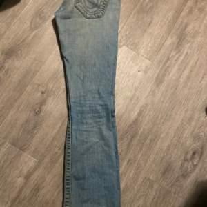 Lågmidjade bootcut jeans från true religion. Säljer eftersom de är för stora. Är i bra skick utöver hålen längst ner i benen 84cm i innerbenslängd 