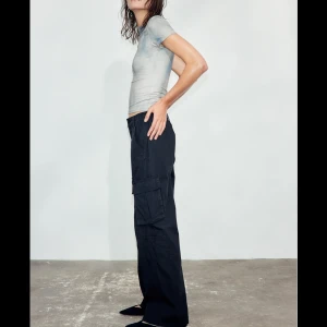 Svarta cargopants - Säljer ett par svarta cargopants i normal passform. De har flera praktiska fickor på sidorna och en elastisk midja för extra komfort. Perfekta för en avslappnad och trendig look!