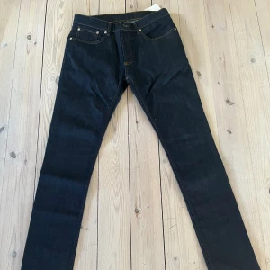 Oandvända Sandro Jeans - Snygga jeans från Sandro Paris i storlek 31, i mörkblå färg. Jeansen är i slim fit och är nya / oandvända. Nypris 1795 kr på NK.