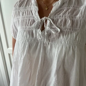 Vit blus med knytning - Säljer en superfin vit luftig blus med korta ärmar och knytning framtill. 🫧🫧