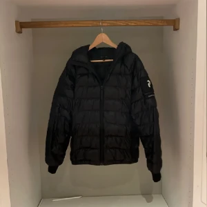 Peak performance jacka  - Säljer denna svarta glansiga peak performance jacka. Skicket är 8/10 och det finns inga defekter eller liknande