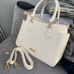 Anna Field väska - har ej använt väska som har en off-white färg! måtten till väskan:  Höjd: 24 cm  Längd: 33 cm Vidd: 11 cm  Handtag: 15 cm