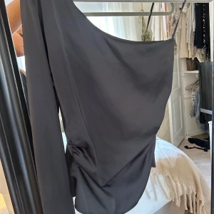 Jätte fin silkes topp - Säljer den här as snygga toppen, som sitter tajt runt midjan, är i silke och ena axeln är framme. Den är verkligen perfekt