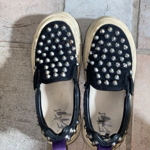 Svarta sneakers med nitar - Säljer ett par unika eytys. Perfekta för att ge din outfit en edgy touch!❤️ Dessa är så coola och gör verkligen en outfit roligare ❤️