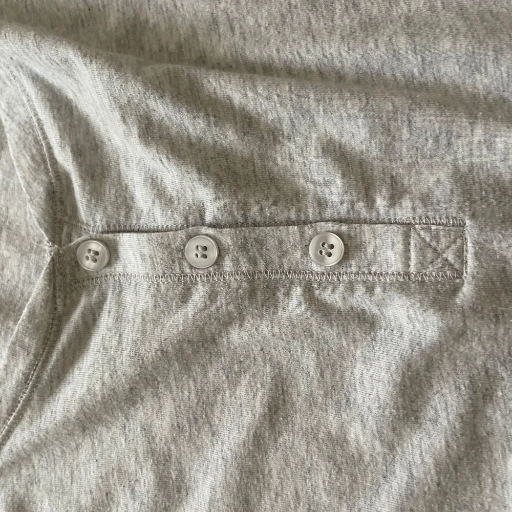 Säljer en enkel och bekväm grå långärmad tröja från Cubus. Den är gjord av 60% bomull och 40% polyester, vilket gör den mjuk och skön att ha på sig. Tröjan har en knappdetalj framtill som ger den lite extra stil. Perfekt för vardagsbruk!. Neuletakit & Villapaidat.