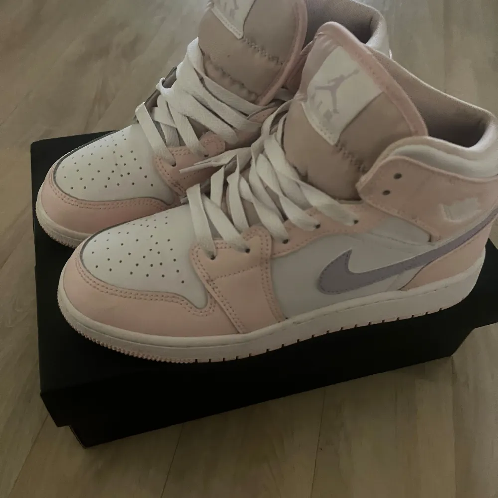 Säljer ett par snygga Nike Air Jordans i en fräsch kombination av rosa och vit. Skorna har en klassisk design med snörning och perforerade detaljer på tån för extra ventilation. De är i bra skick och perfekta för både vardag och fest.. Kengät.