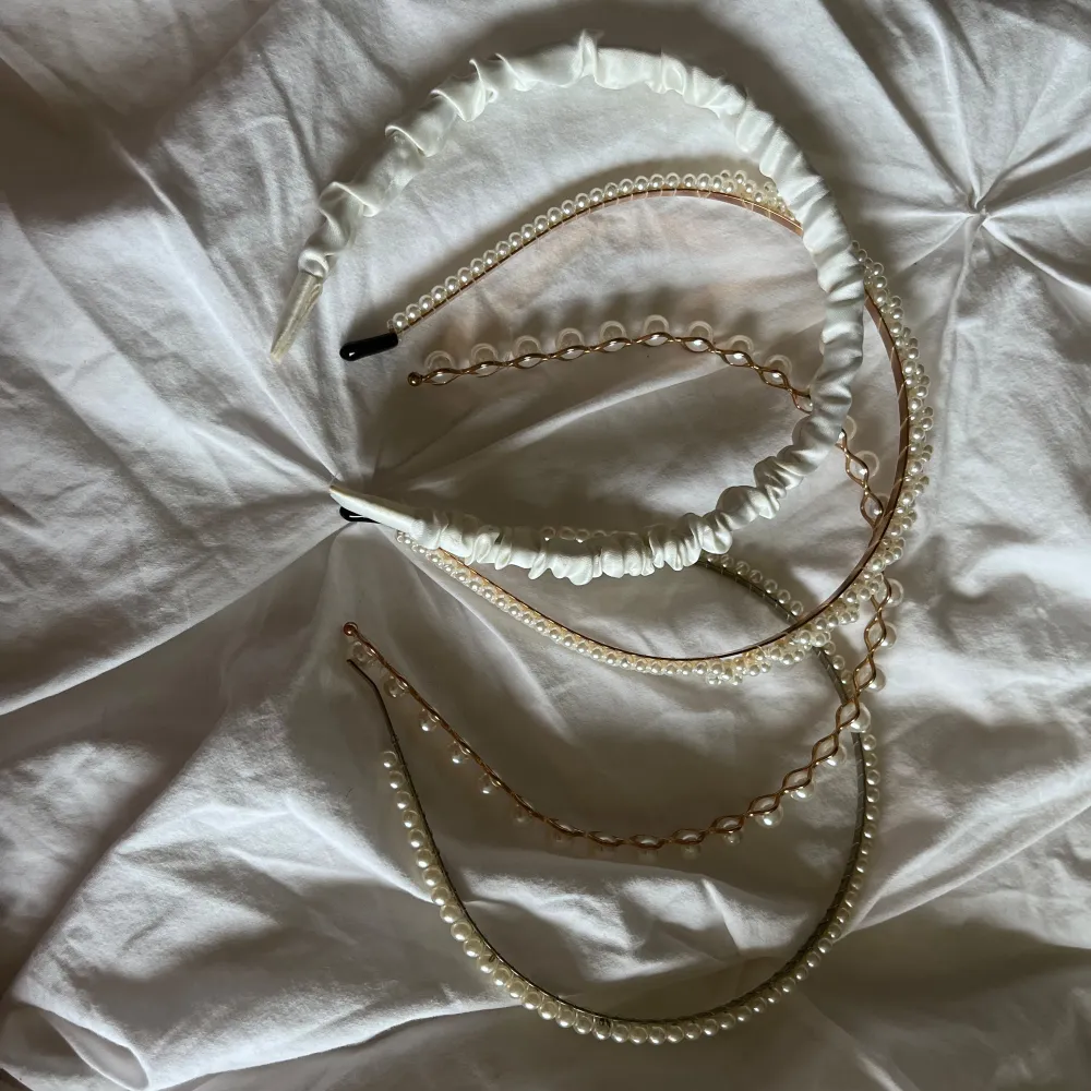 Säljer ett set med flera diadem i olika stilar. Ett vitt diadem med pärlor som ger en elegant touch, perfekt för festliga tillfällen. Ett annat diadem är ribbat och svart, vilket ger en mer vardaglig och stilren look. Alla diadem är i nyskick och redo att användas för att komplettera din outfit! !paket pris! . Accessoarer.