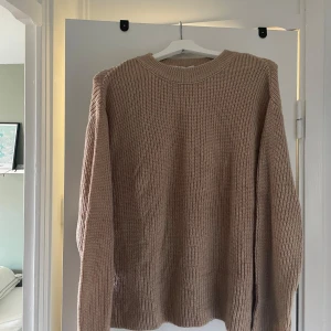 Stickad tröja från Na-kd - Snygg stickad tröja i en ljus beige färg. Tröjan har en rund halsringning och långa ärmar. Den är i en mjuk och skön kvalitet. Storlek L