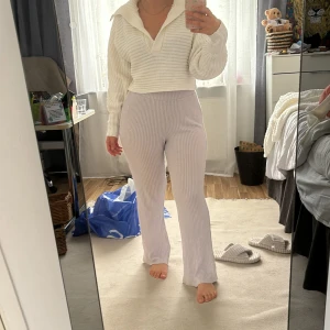 Vit stickad croppad tröja - Säljer en superfin vit stickad tröja som är croppad och har en snygg v-ringad design. Den är perfekt för både höst och vinter och ger en mysig känsla. Tröjan har långa ärmar och en loose passform som gör den bekväm att bära. Perfekt för att matcha med höga byxor eller kjolar!