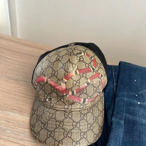 Gucci keps - Säljer nu min snygga beiga gucci keps med ormen på. Använder inte keps längre så känns onödigt att ha kvar den. Den är lite sliten för jag haft den flera år. Därlfr säljer jag den till ett bra pris. Priset går att diskutera.