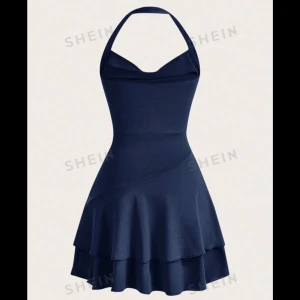 Mörkblå klänning - Snygg mörkblå klänning från Shein med halterneck och volangdetaljer. Perfekt för sommarens fester eller en kväll ute. Den har en figurnära passform upptill och en utsvängd kjol som ger en fin siluett.