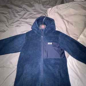 Mörkblå fleecejacka från Helly Hansen - Säljer en skitfet mörkblå fleecejacka från Helly Hansen. Storleken är barn 176/16 år men sitter som S/M. Den är bara testad så den är i helt oanvänt skick! Nypris 1000, mitt pris 800. Hör av er vid minsta lilla fundering! 😊
