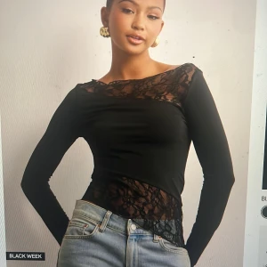 Svart långärmad topp med spetsdetaljer - Snygg svart långärmad topp med spetsdetaljer på ärmar och runt halsen. Perfekt för en kväll ute eller en fest. Toppen har en tight passform och är gjord i ett mjukt och stretchigt material för extra komfort. Nypris 349kr