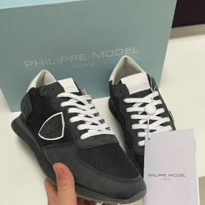 Philippe Model Trainers - Snygga Philippe Model sneakers i svart och vit med snörning. Skorna har en stilren design med en kombination av skinn och syntetmaterial. Perfekta för både vardag och festliga tillfällen. Fraktas i orginalbox, helt oanvändba