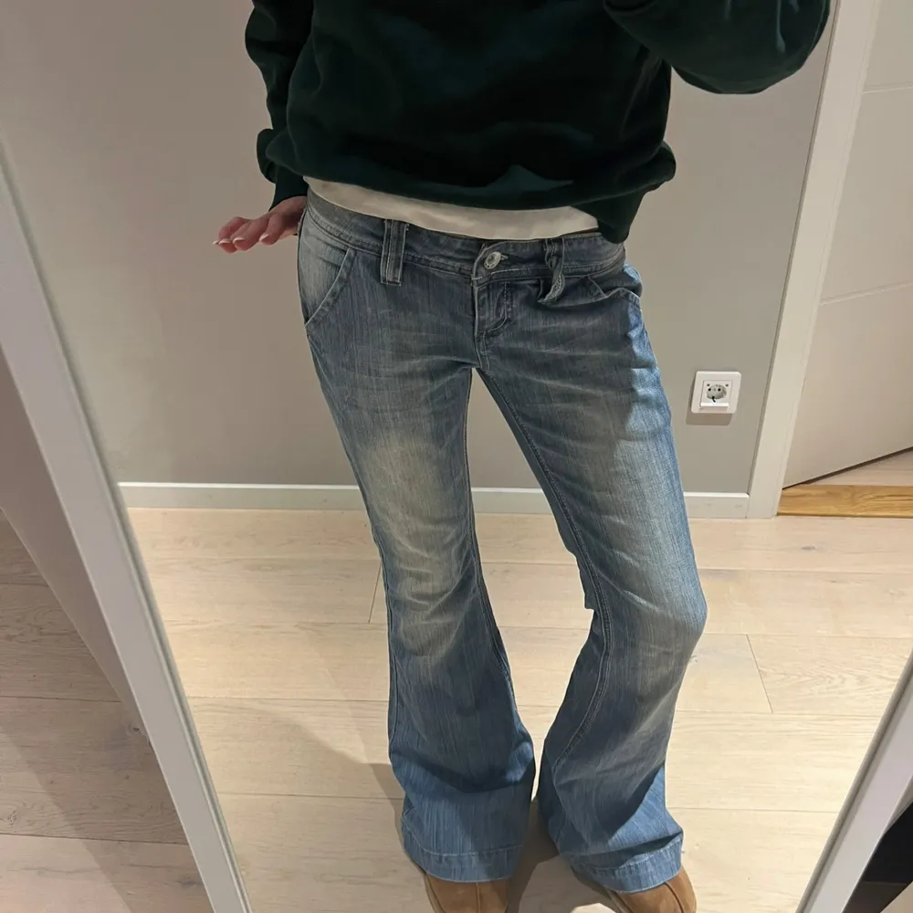 Säljer ett par snygga blå bootcut jeans i bra skick. De är lågmidjade och har en klassisk femficksdesign med knapp och dragkedja fram. Perfekta för en avslappnad vardagslook eller en utekväll. Passar bra med sneakers eller boots! Sjukt snygga och populära💗😋🥹✨Midjemått: ca 36 cm rakt över och innerbenslängd: ca 79cm🥹🥹💗☺️🧘‍♀️. Jeans & Byxor.