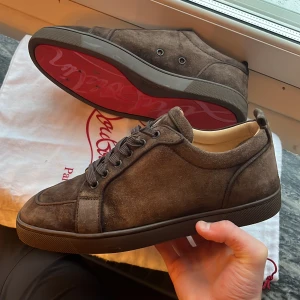 Christian Louboutin skor - Säljer ett par snygga bruna sneakers i mocka från Christian Louboutin. De är i fint skick. Storlek 41 men passar även 42. Tveka inte på att höra av er vid flera frågor 