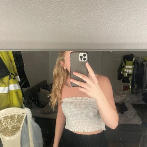 Vit smockad tubtopp - Säljer en söt vit smockad tubtopp som är perfekt för sommaren. Toppen är ärmlös och har en elastisk passform som gör den bekväm att bära. 🤍🤍🤍