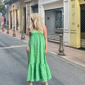 Grön lång klänning - Säljer en superfin grön klänning i ett lätt och luftigt material. Perfekt för sommardagar och midsommarfirande. Klänningen har en volangdetalj längst ner och en smickrande passform. Den är lång och har en härlig, ljusgrön färg som verkligen poppar! Storlek S, men passar XS-M pga resor och band baktill. 