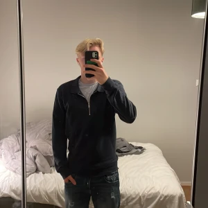 Marinbla zip-up - Säljer en stilren quarter-zip. Perfekt för både vardag och finare tillställningar. Tröjan har en krage och är i mycket bra skick. Storlek L