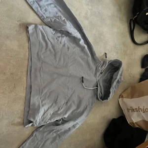Grå hoodie  - Säljer en snygg och bekväm grå hoodie som är croppad. Osäker på märke men i fint skick