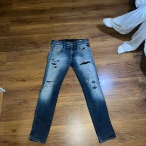 Blå slitna jeans - Säljer ett par snygga blå jeans med slitningar för en cool look. De har en slim passform och är perfekta för både vardag och fest. Modellen är 182 o väger 72 och dem är  i bra skick. Perfekta för dig som vill ha en avslappnad men stilren stil.