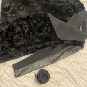 Svart pälsjacka från ONLY - Säljer en snygg svart pälsjacka från ONLY i storlek M. Jackan har en lyxig känsla med sitt mjuka pälsmaterial och stilrena design. Perfekt för höst och vinter, och den har ett bälte för att framhäva midjan. Ärmarna är långa och i ett glansigt material som ger en cool kontrast. Passar storlek s 