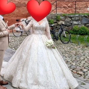 Elegant brudklänning med spetsdetaljer - Säljer en fantastisk brudklänning i beige med vackra spetsdetaljer och lång ärm. Klänningen har en imponerande lång kjol och en elegant v-ringning. Perfekt för ett sagolikt bröllop! Finns möjlighet att diskutera priset 