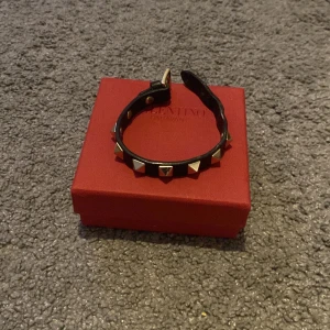 Valentino Armband - Säljer mitt Valentino Armand med guldiga nitar. Armbandet är i använt skick men har mycket kvar att ge. Nypris: 3000 Mitt pris: 1100