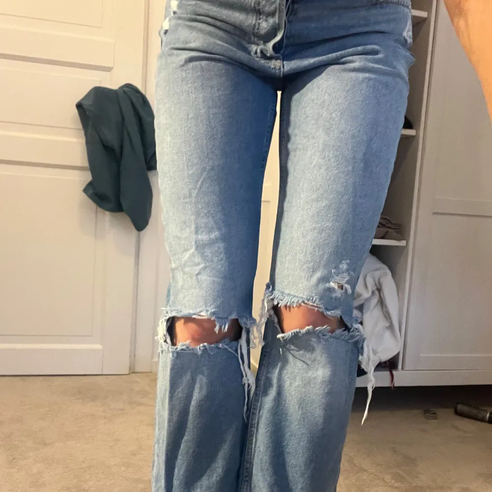 Säljer ett par snygga blå zara jeans med slitningar på knäna. De har en straight passform och är i bra skick. Perfekta för en avslappnad stil och kan matchas med nästan vad som helst. Passar både till vardags och fest! Använda Max 5 gånger så i bra skick. Jag är 176☺️💕. Farkut & Housut.