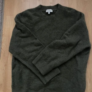 Grön ulltröja från &otherstories - Säljer en supermysig grön ulltröja från &otherstories i storlek M. Perfekt för kyliga höst- och vinterdagar. nypris cirka 800kr säljes för 100