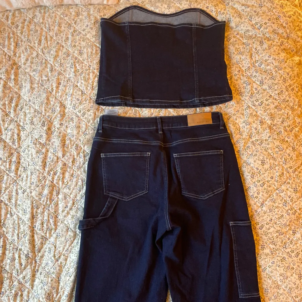 Säljer snygg croppad tubtopp och matchande jeans i stretchigt jeansmaterial från Noisy May x Emilie Malou. Mycket bra skick, setet är använt endast en gång. Top i storlek L & jeans: waist 31 & length 34. Jeans & Byxor.